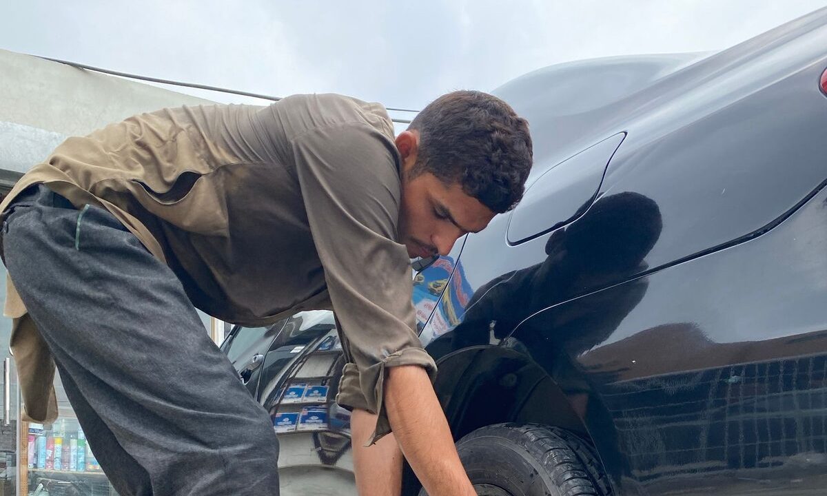 Yol kenarinda bijon anahtariyla lastik degistiren surucu