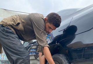 Yol kenarinda bijon anahtariyla lastik degistiren surucu